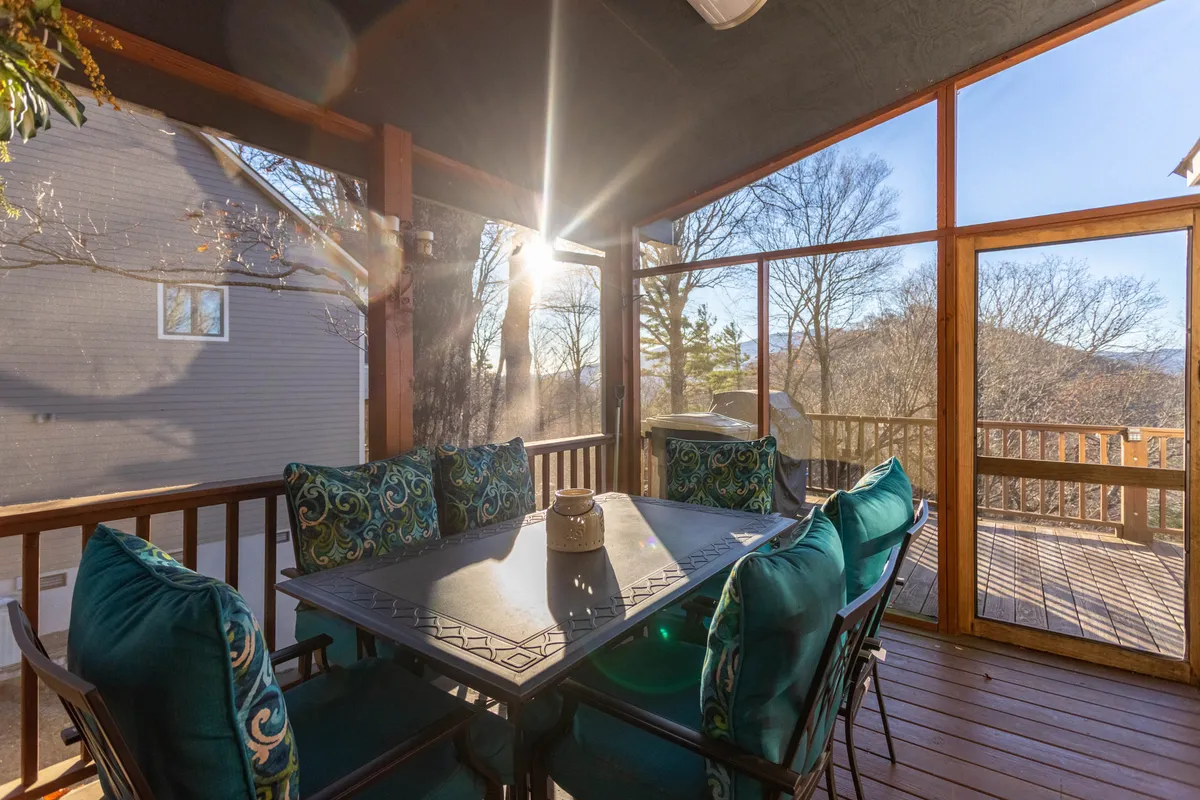 A relaxed dining nook with a large table surrounded by decorative pillows and expansive windows, capturing soft natural light. The setting is perfect for shared meals, morning coffee, or enjoying sunset views with friends.